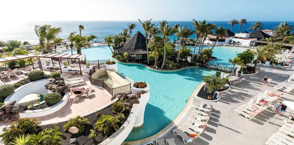 Le cadre tropical de l'hôtel Club Jandia Princess, avec sa piscine bordée de palmiers et sa vue sur l'océan.