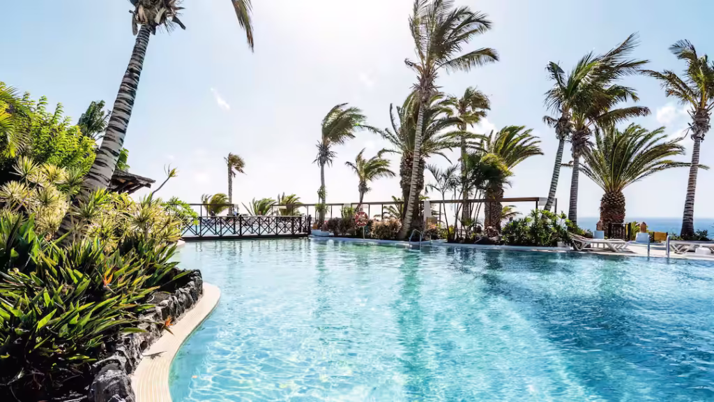 Tropical setting of Hotel Club Jandia Princess featuring palm-lined pool area